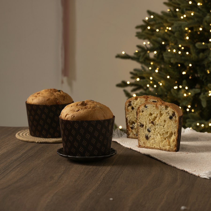 Panetones embalados em cima da mesa, ao lado da árvore de Natal